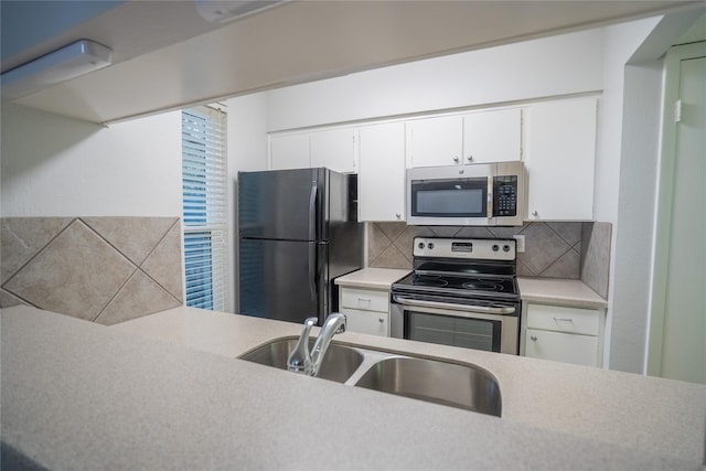 kitchen featuring backsplash, sink, white cabinetry, and stainless steel appliances