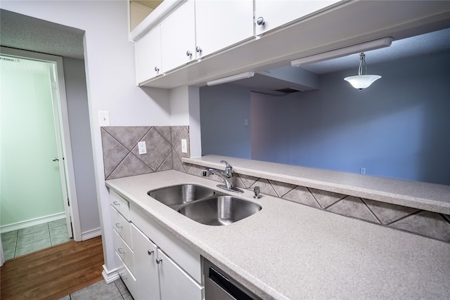 kitchen with white cabinetry, sink, light tile patterned floors, and decorative light fixtures