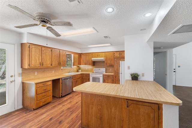 kitchen featuring a wealth of natural light, white appliances, kitchen peninsula, and light wood-type flooring