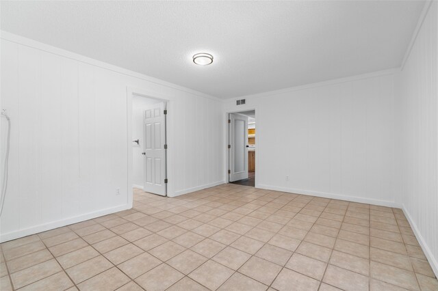 spare room featuring crown molding and light tile patterned flooring