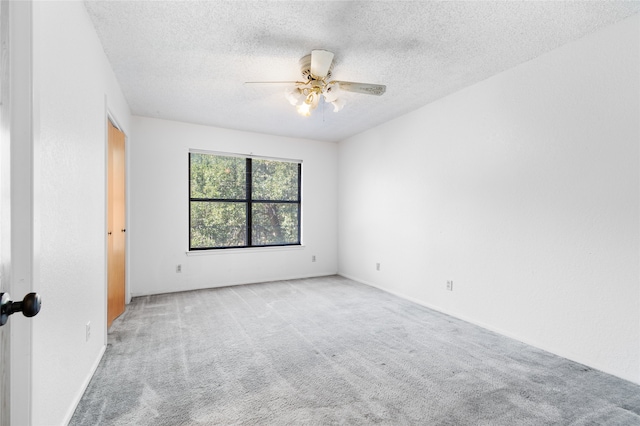 unfurnished room with a textured ceiling, ceiling fan, and light carpet