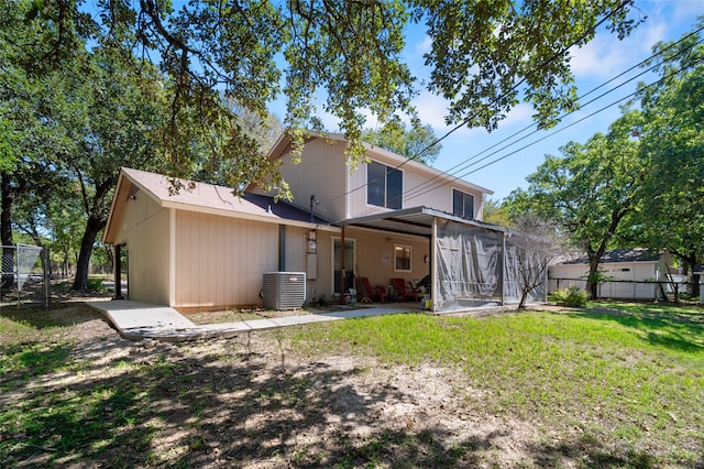 rear view of property with a sunroom, central AC unit, a patio area, and a yard