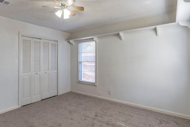 unfurnished bedroom featuring ceiling fan, light colored carpet, and a closet