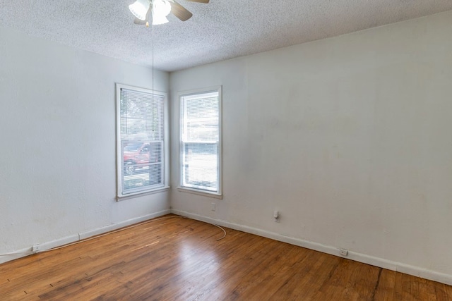 spare room with a textured ceiling, hardwood / wood-style flooring, and ceiling fan