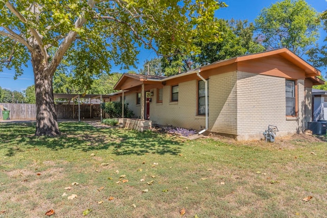 rear view of property with a yard and central AC unit