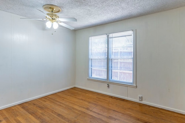 unfurnished room featuring ceiling fan, hardwood / wood-style flooring, and a textured ceiling