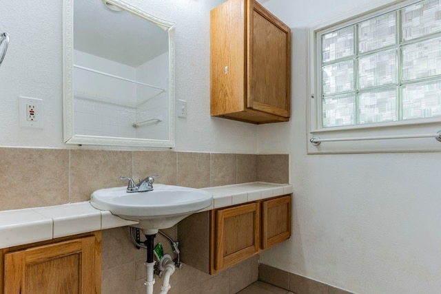 bathroom featuring backsplash and sink