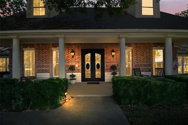 exterior entry at dusk featuring covered porch