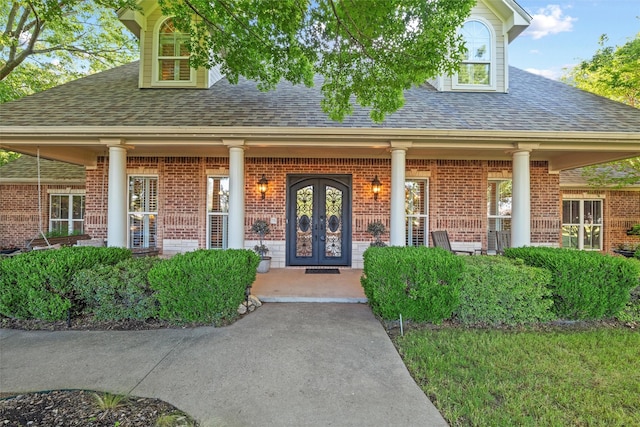 102 Ridge Ct, Glen Rose, TX 76043 - view of exterior entry with roof with shingles, covered porch, brick siding, and french doors