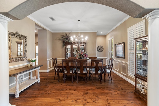 dining area with dark hardwood / wood-style flooring, ornamental molding, and a notable chandelier