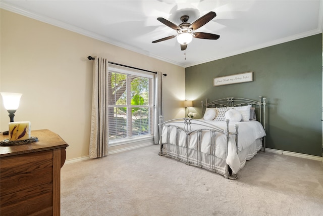 carpeted bedroom with ceiling fan and ornamental molding