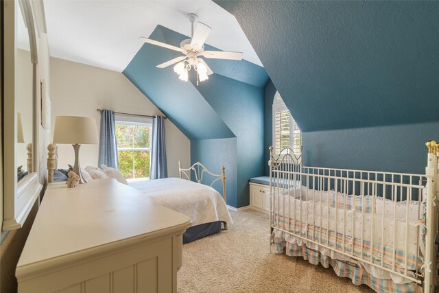 carpeted bedroom with ceiling fan and vaulted ceiling