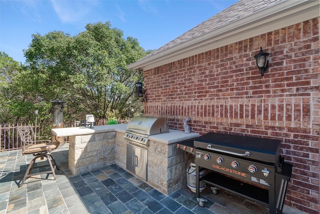 view of patio featuring an outdoor kitchen, an outdoor bar, and grilling area