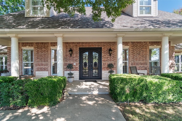 entrance to property featuring covered porch and french doors