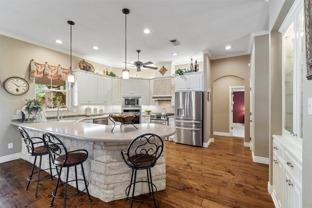 102 Ridge Ct, Glen Rose, TX 76043 - kitchen with appliances with stainless steel finishes, a kitchen breakfast bar, a sink, decorative backsplash, and ornamental molding