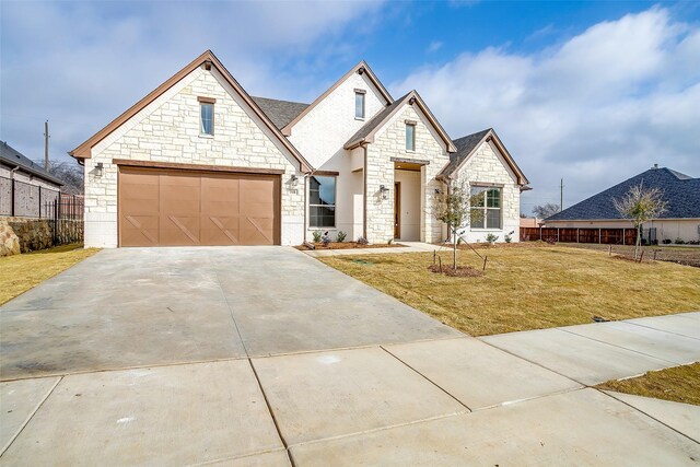 french country inspired facade with a garage and a front lawn