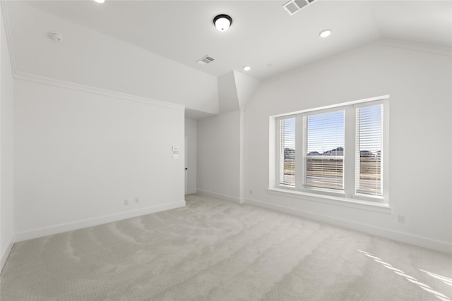 carpeted spare room featuring crown molding and lofted ceiling