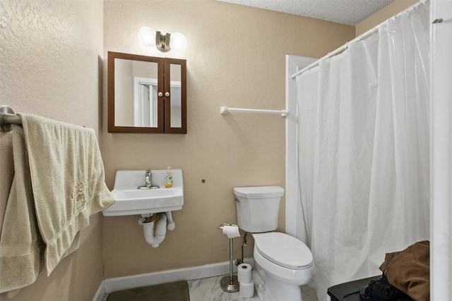 bathroom with walk in shower, a textured ceiling, sink, and toilet