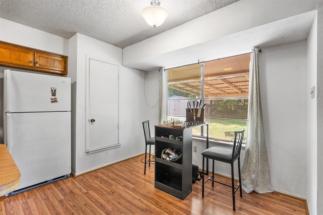 dining space featuring light hardwood / wood-style floors and a textured ceiling