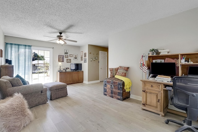 living room featuring a textured ceiling, light hardwood / wood-style floors, and ceiling fan