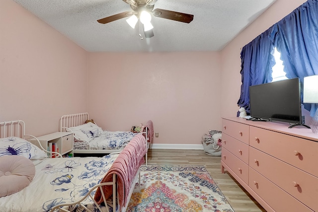 bedroom featuring a textured ceiling, ceiling fan, and light hardwood / wood-style flooring