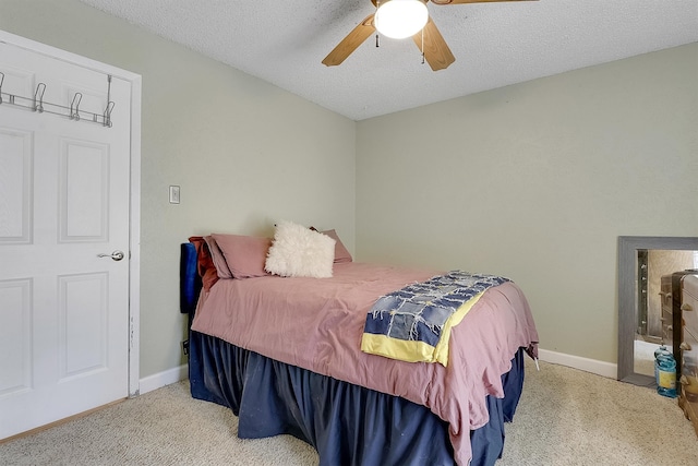 carpeted bedroom with ceiling fan and a textured ceiling