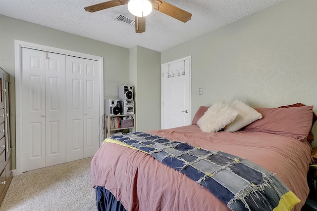 bedroom featuring a closet, carpet, ceiling fan, and a textured ceiling