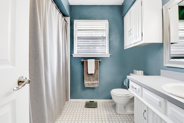 bathroom featuring tile patterned floors, curtained shower, vanity, and toilet