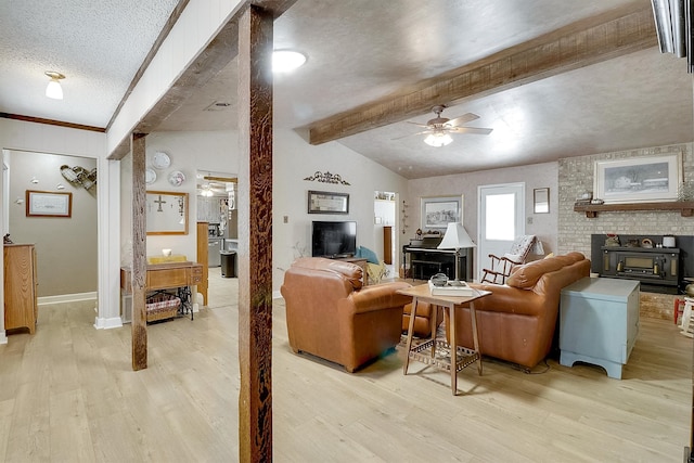 living room with ceiling fan, vaulted ceiling with beams, a textured ceiling, and light hardwood / wood-style floors