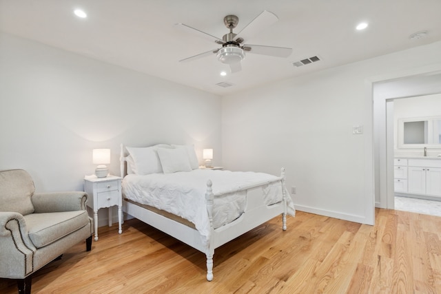 bedroom with ceiling fan, light hardwood / wood-style flooring, and sink