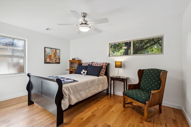 bedroom featuring multiple windows, ceiling fan, and light hardwood / wood-style flooring