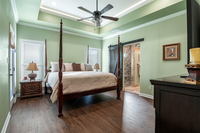 bedroom featuring ceiling fan, a raised ceiling, a barn door, dark hardwood / wood-style floors, and ornamental molding