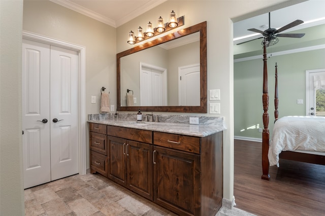 bathroom featuring hardwood / wood-style floors, ceiling fan, ornamental molding, and vanity