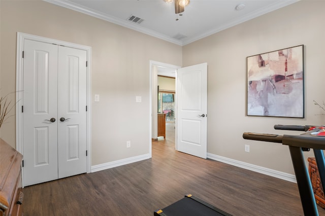 exercise room with ornamental molding, ceiling fan, and dark wood-type flooring