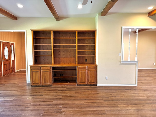 unfurnished living room featuring ceiling fan, baseboards, dark wood-type flooring, and beamed ceiling