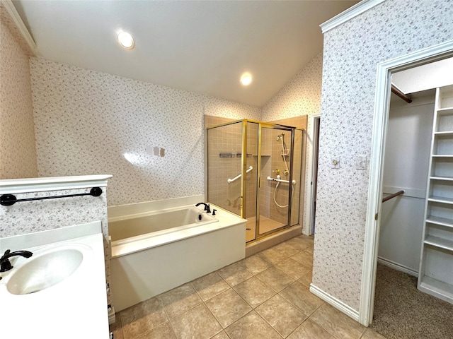bathroom with a spacious closet, a shower stall, a bath, and wallpapered walls