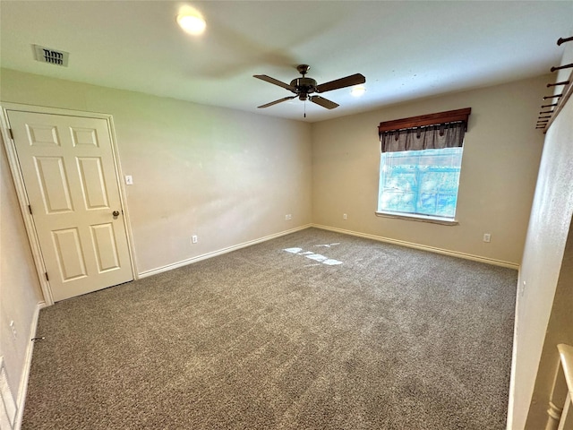 carpeted spare room featuring baseboards, a ceiling fan, and visible vents