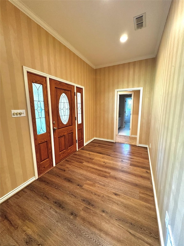 foyer with wallpapered walls, wood finished floors, visible vents, crown molding, and baseboards