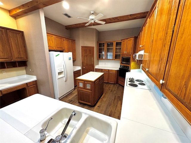 kitchen with brown cabinetry, dark wood finished floors, visible vents, and white appliances