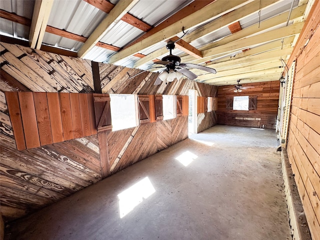 bonus room with wooden walls and ceiling fan