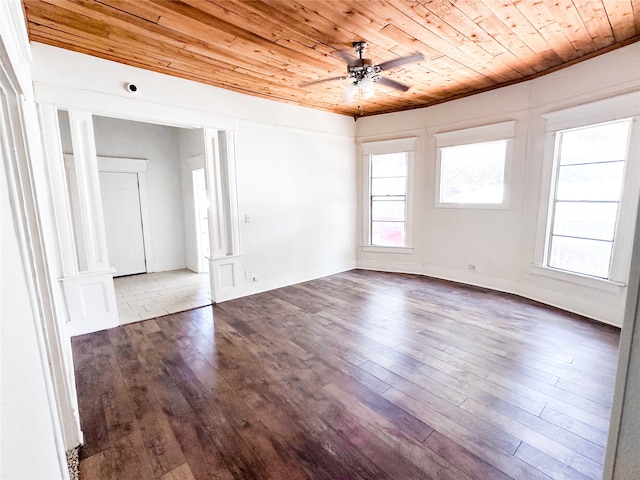 spare room featuring ceiling fan, wooden ceiling, dark wood-type flooring, and crown molding