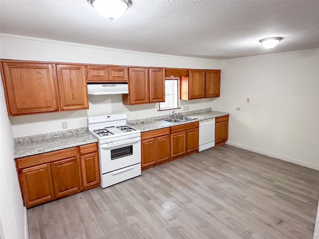 kitchen with light hardwood / wood-style floors, a textured ceiling, white appliances, and sink