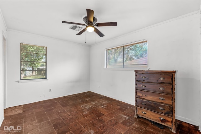 empty room with ceiling fan, plenty of natural light, and crown molding