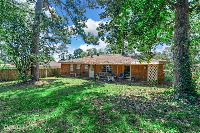 rear view of house featuring a lawn, cooling unit, and a patio area