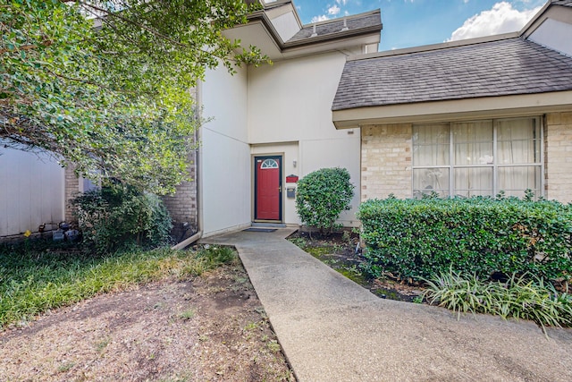 13818 Methuen Green Ln, Dallas, TX 75240 - doorway to property featuring stucco siding, brick siding, and a shingled roof