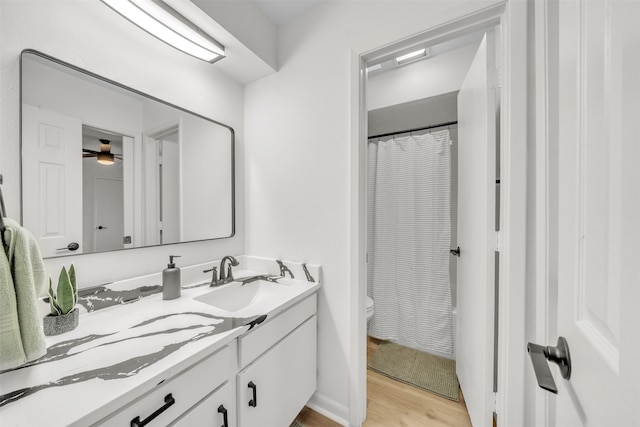 bathroom with ceiling fan, hardwood / wood-style flooring, vanity, and toilet