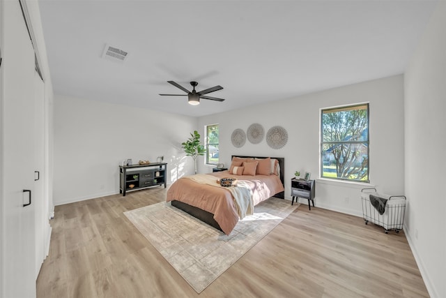 bedroom featuring light hardwood / wood-style floors, multiple windows, and ceiling fan