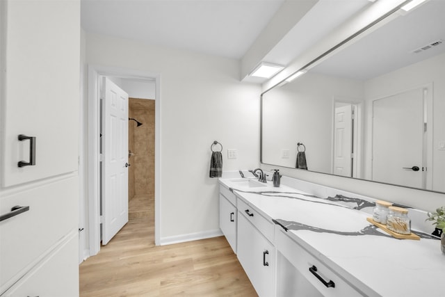 bathroom with vanity, a shower, and hardwood / wood-style flooring