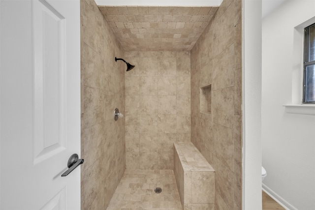 bathroom featuring toilet and tiled shower