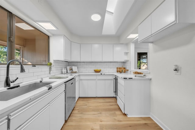 kitchen with white cabinets, dishwasher, and sink